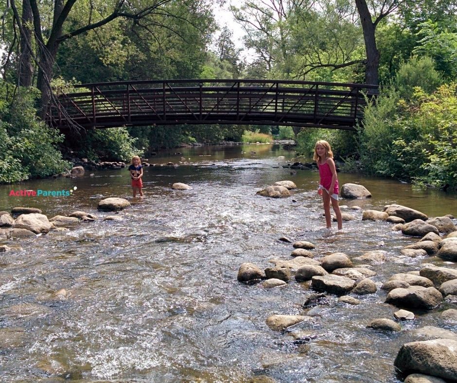Two girls creekwalking in Bronte Creek at Lowville Park in Burlington.