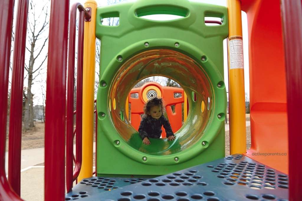 little one climbing through tunnel