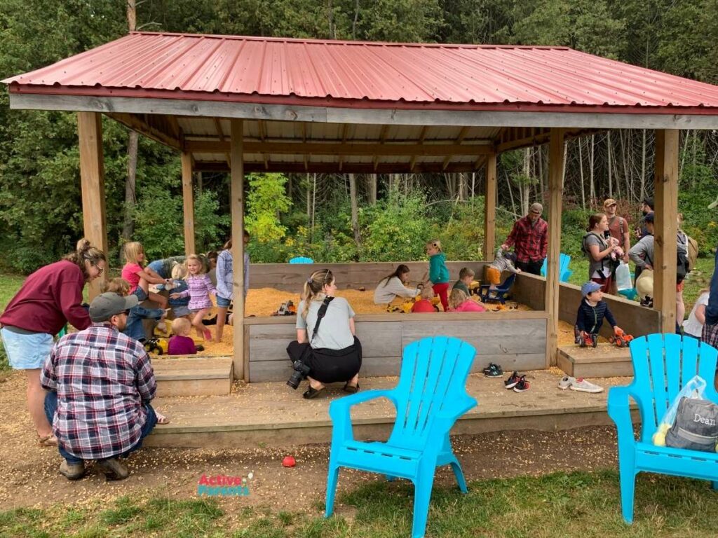 Families playing at the corn kernel filled sandbox at The Apple Orchard in Hamilton